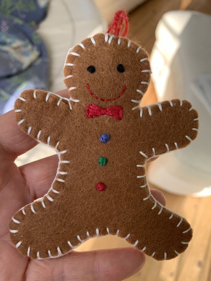 a hand holding a brown felt ginger ornament