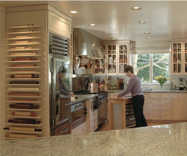 a woman standing at the counter in a kitchen