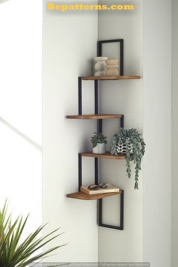 three shelves with plants and books on them in the corner of a living room, against a white wall