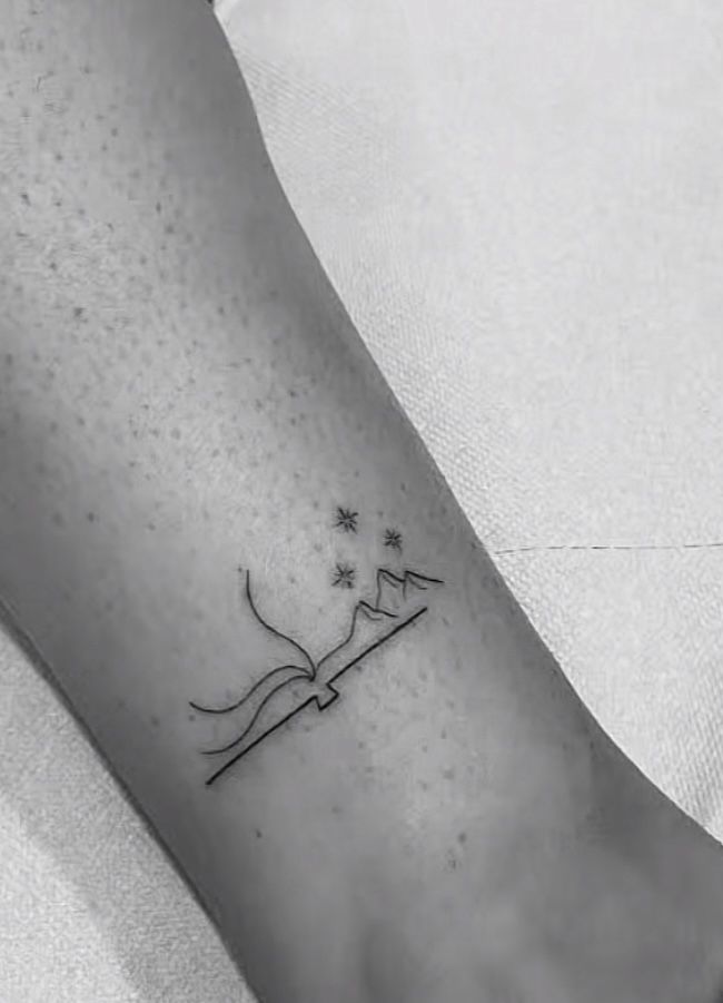 a person's foot with a small tattoo on the left side of their leg