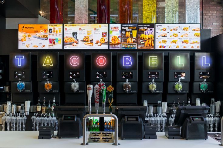 there are many different types of drinks on the bar at this restaurant, including soda machines