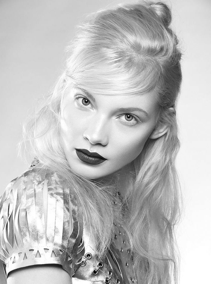 black and white photograph of a woman with long blonde hair, wearing a silver dress