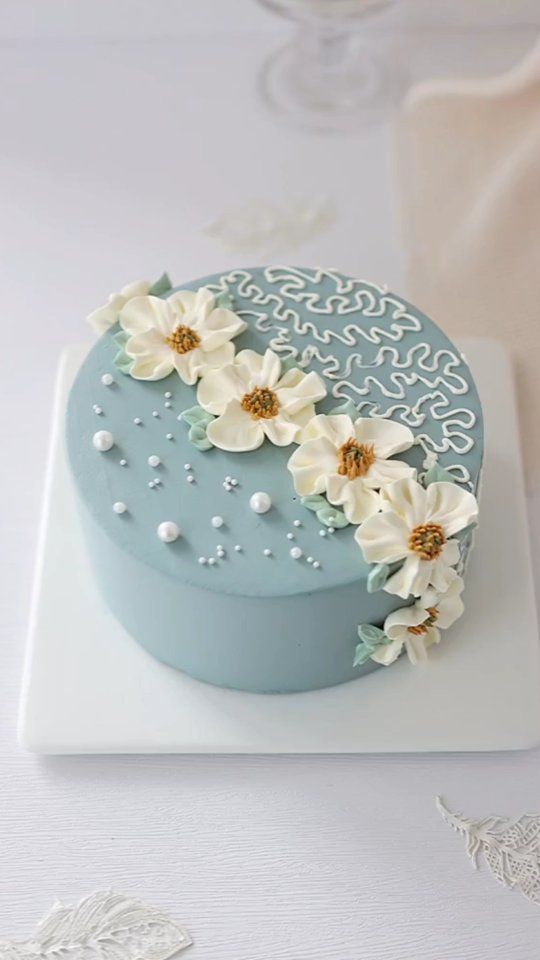 a blue cake with white flowers on it