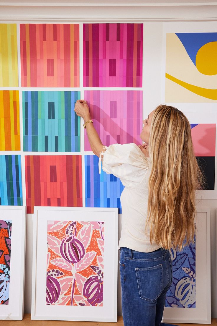 a woman is painting colorful art on the wall