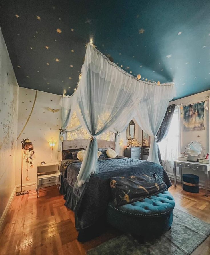 a canopy bed in a bedroom with blue walls and wooden floors, decorated with stars