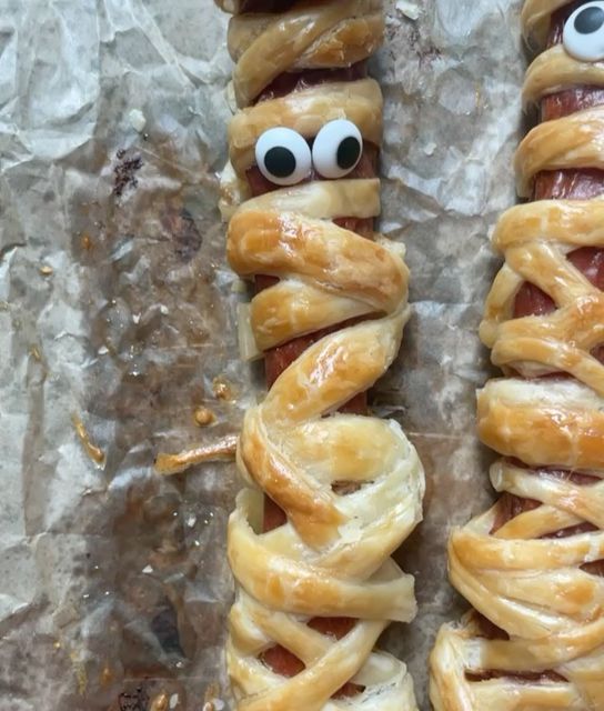 two hot dogs wrapped in pretzels with googly eyes