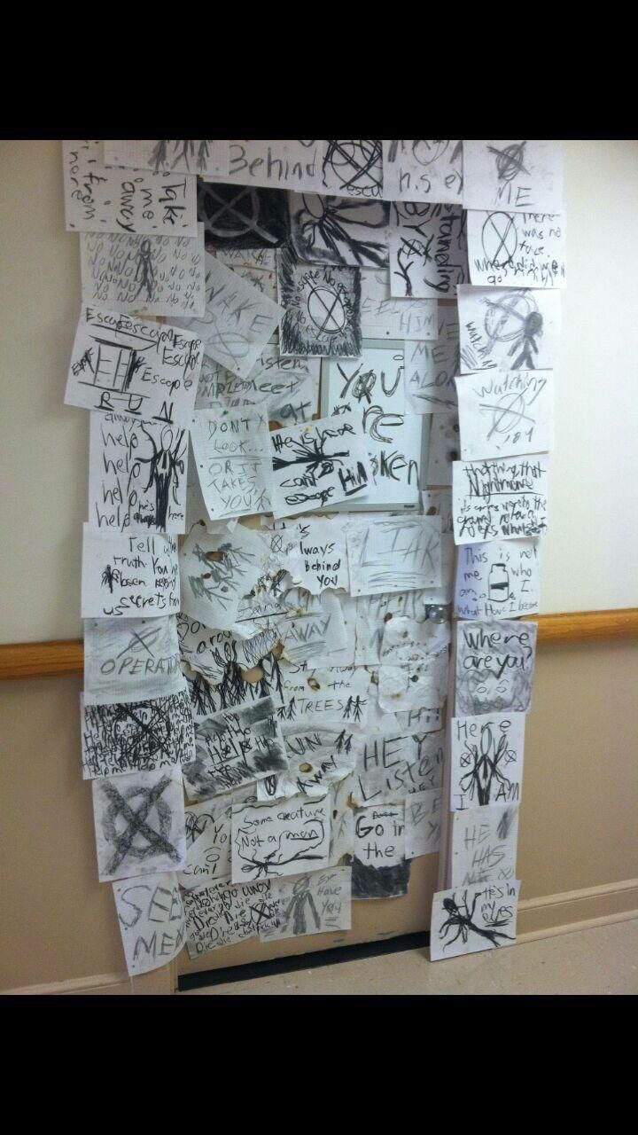 a wall covered with lots of writing and pictures on it's side, next to a doorway