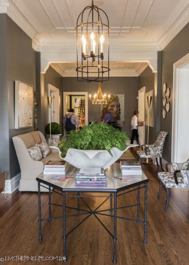 a living room filled with furniture and a chandelier hanging over the top of it