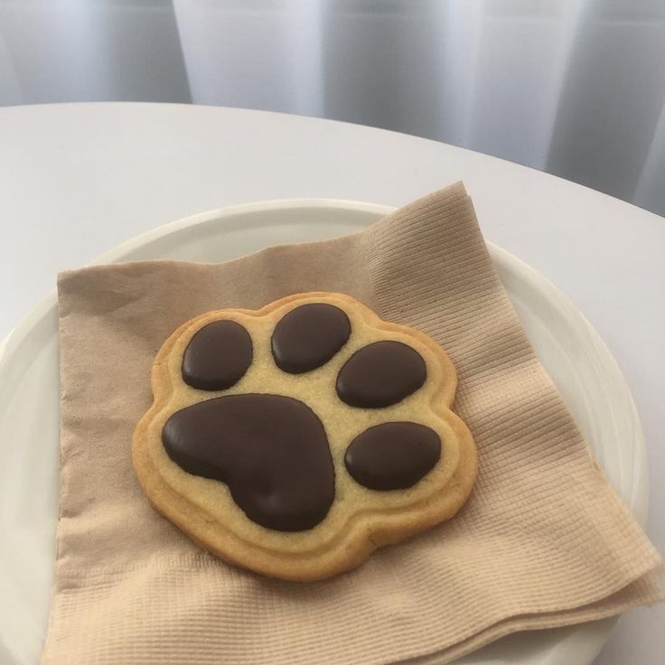 a cookie shaped like a paw on top of a napkin