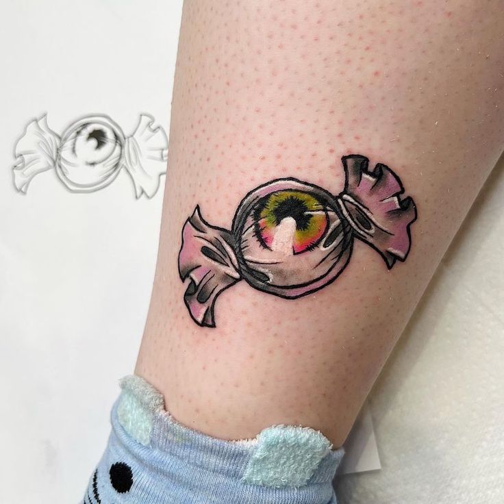 a woman's leg with an eyeball tattoo on it