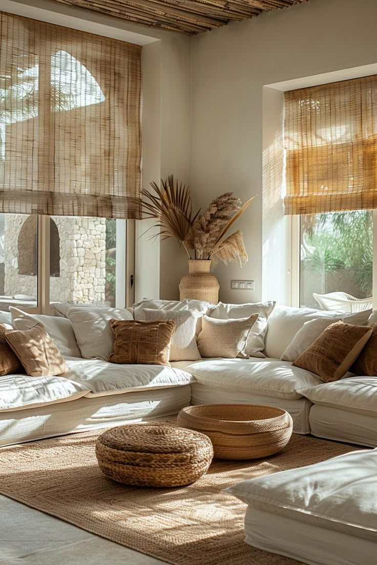 a living room filled with lots of white furniture and pillows on top of a rug