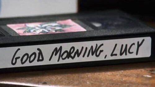 a close up of a book with writing on it sitting on a wooden table next to a cup