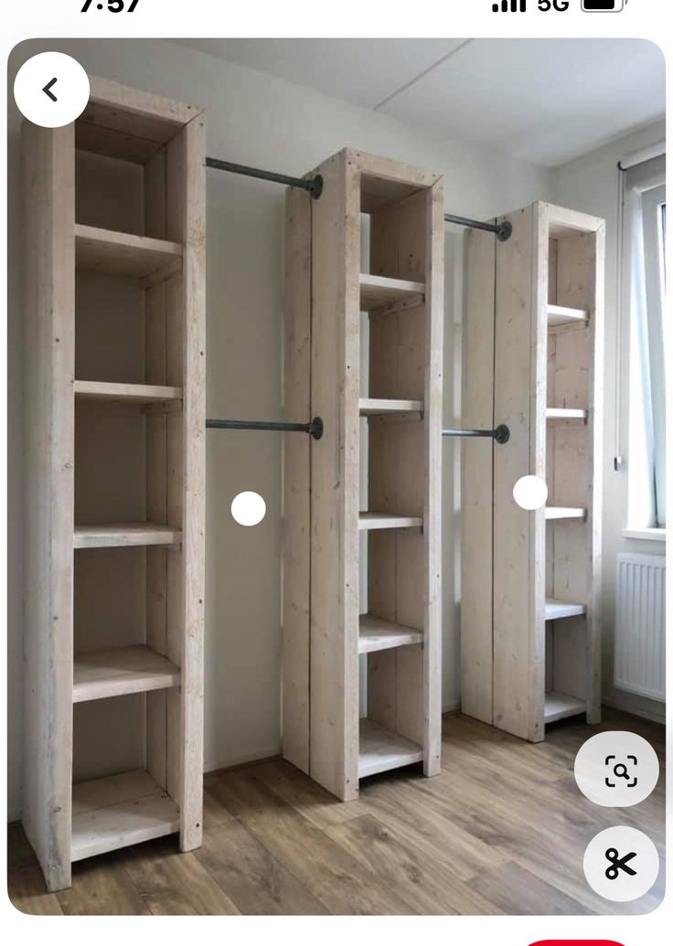 an empty room with some shelves on the wall and two doors open to reveal closet space