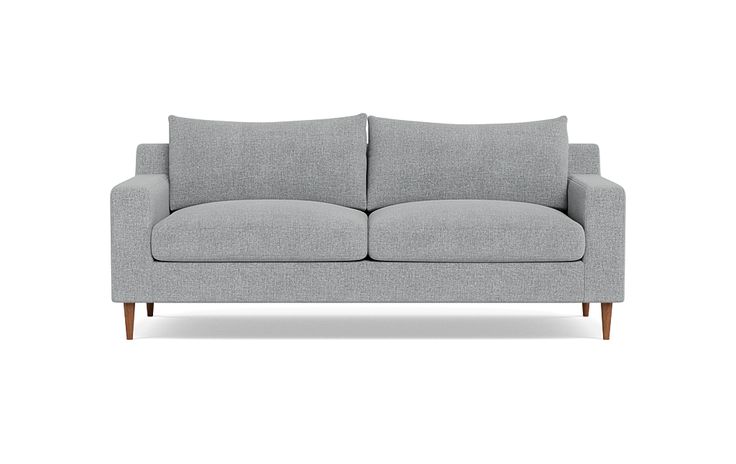 a gray couch with two pillows on it's back and one arm facing the camera