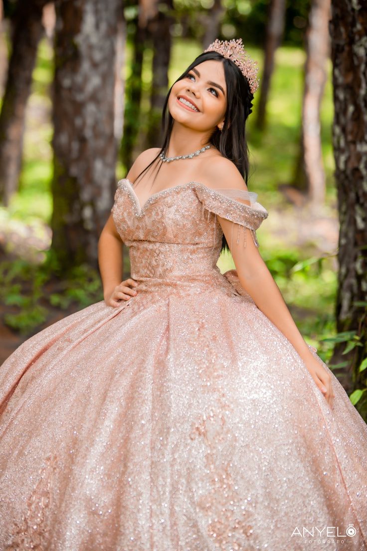 a woman in a pink ball gown posing for the camera with her hands on her hips