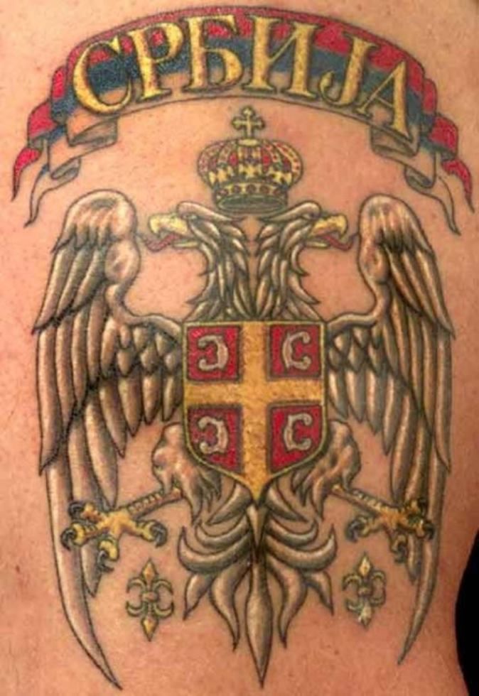 the back of a man with an eagle and cross tattoo on his chest, which reads oppenia