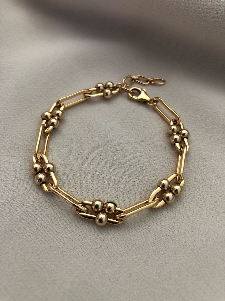 "A thick gold, long link bracelet with moving ball details. Made of high quality 14kt gold filled, this bracelet is a timeless staple for your wardrobe. Chain width is approximately 5.5mm. Gold filled balls are approximately 4mm. This listing is for the single gold chain bracelet. Measures: S/M 6\" with 1\" extender M/L 7\" with 1\" extender Length pictured at S/M ------------------------------------------------------------------------------------------------------------------- >> Check ou Luxury Gold Link Bracelet Fine Jewelry, Elegant Luxury Oval Chain Bracelet, Gold Bracelets With Satellite Chain For Formal Occasions, Formal Gold Bracelets With Satellite Chain, 14kt Gold Jewelry, Dope Jewelry Accessories, Gold Chain Bracelet, Gold Link Bracelet, Stacked Necklaces