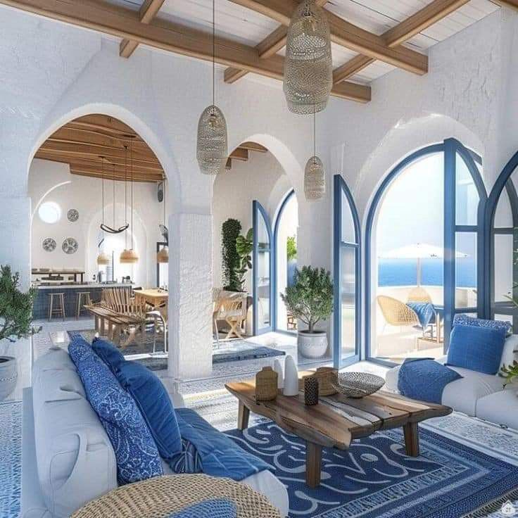 a living room filled with lots of furniture next to an open window covered in blue and white curtains