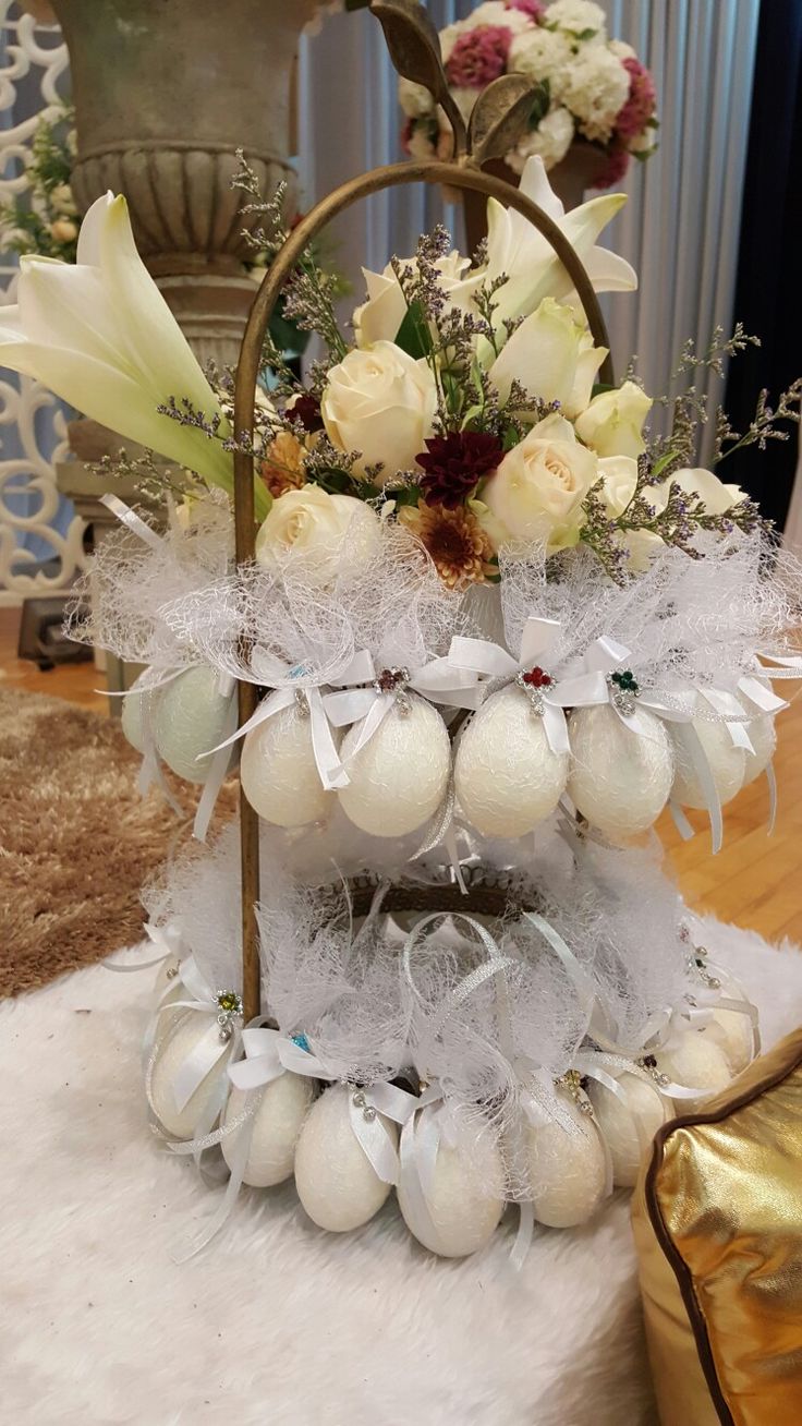 a basket filled with white flowers and eggs