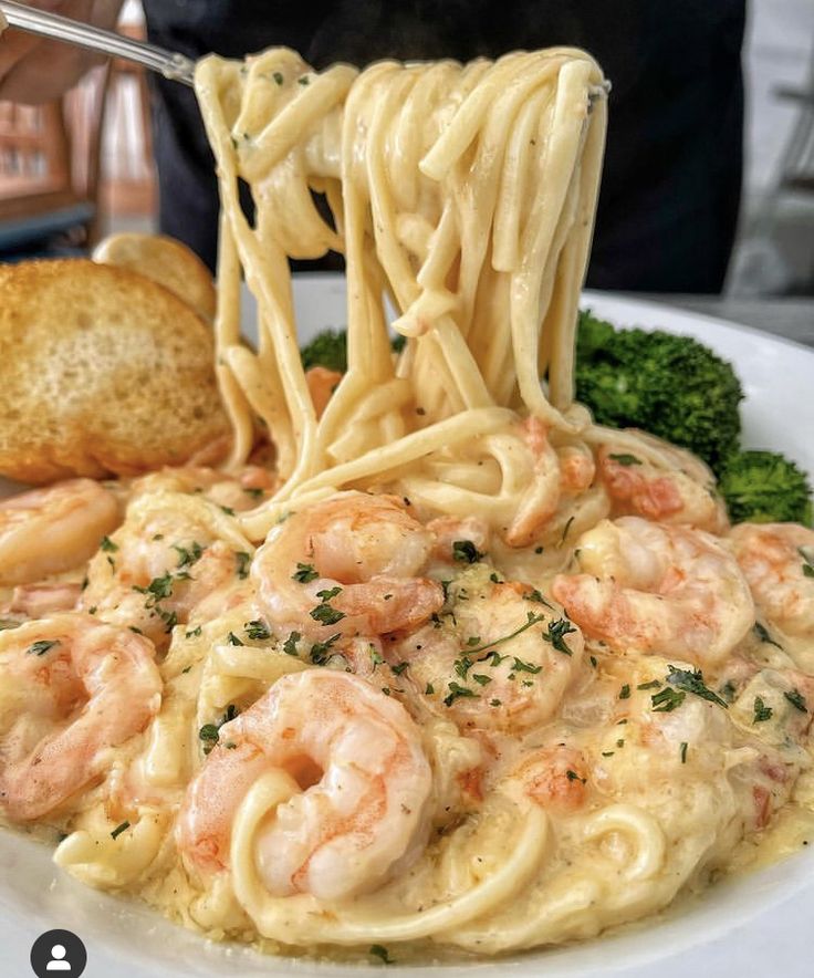 a white plate topped with pasta and shrimp