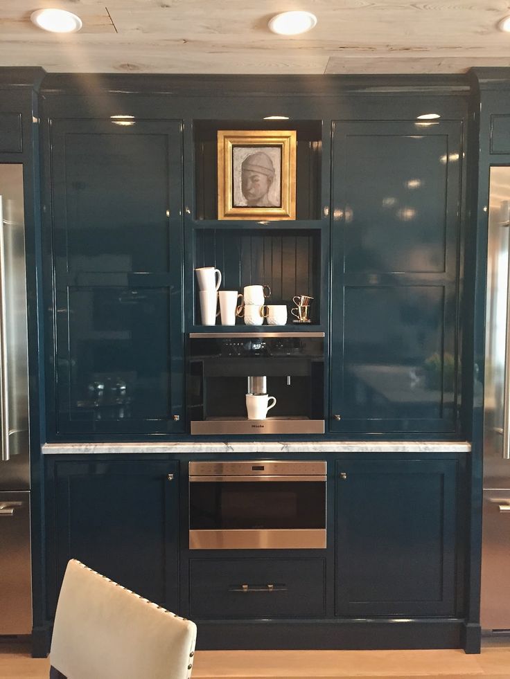 a kitchen with blue cabinets and white chairs