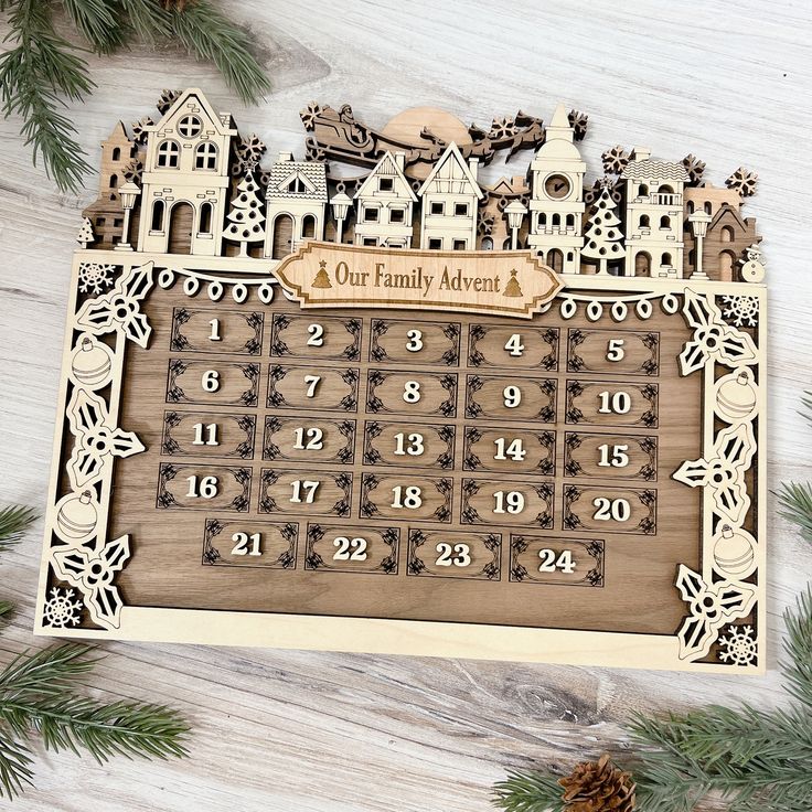 a wooden calendar sitting on top of a table next to pine cones and christmas decorations