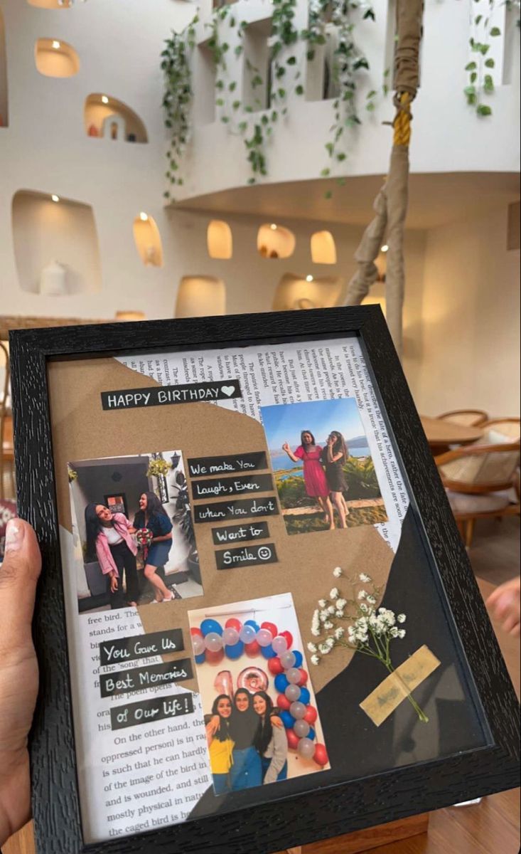 a person holding up a framed photo with photos on it