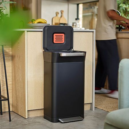 a black trash can sitting in the middle of a kitchen