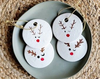 three snowman ornaments are on a plate