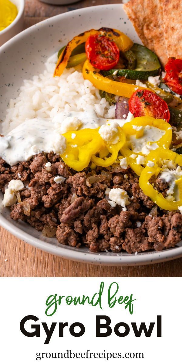 ground beef and vegetables with rice in a white bowl on a wooden table next to pita bread