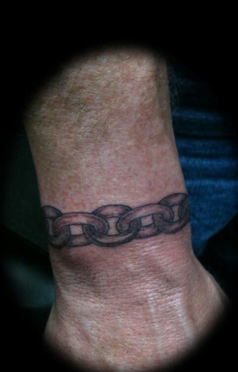 a man's foot with a chain tattoo on it