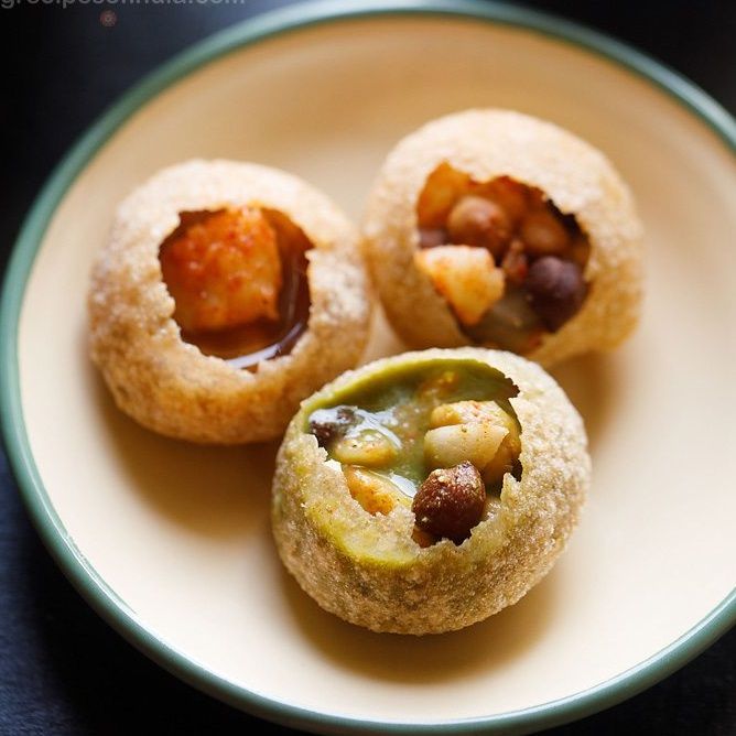 three small pastries on a plate with some fillings in the middle and one filled with nuts