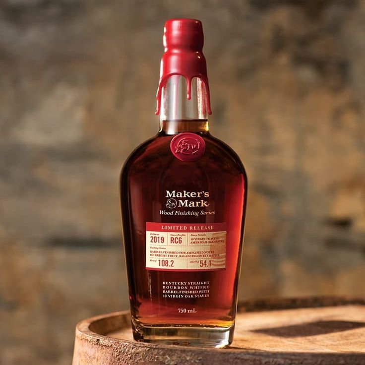 a bottle of maker's mark whiskey sitting on top of a barrel