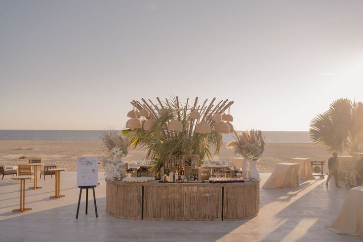 the table is set up on the beach for an outdoor wedding reception with palm trees in the background