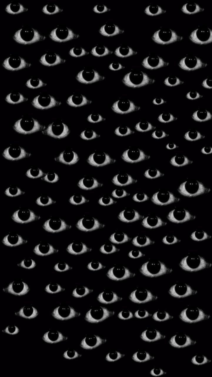 black and white photograph of many eyes in the dark, with only one eye visible