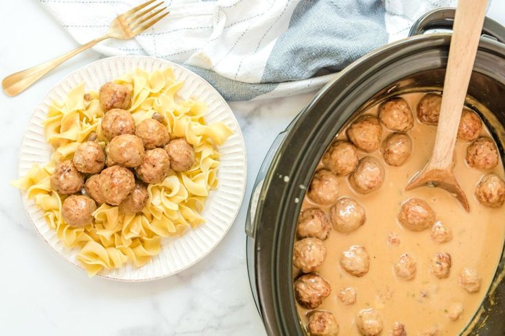 meatballs and noodles are being cooked in the slow cooker