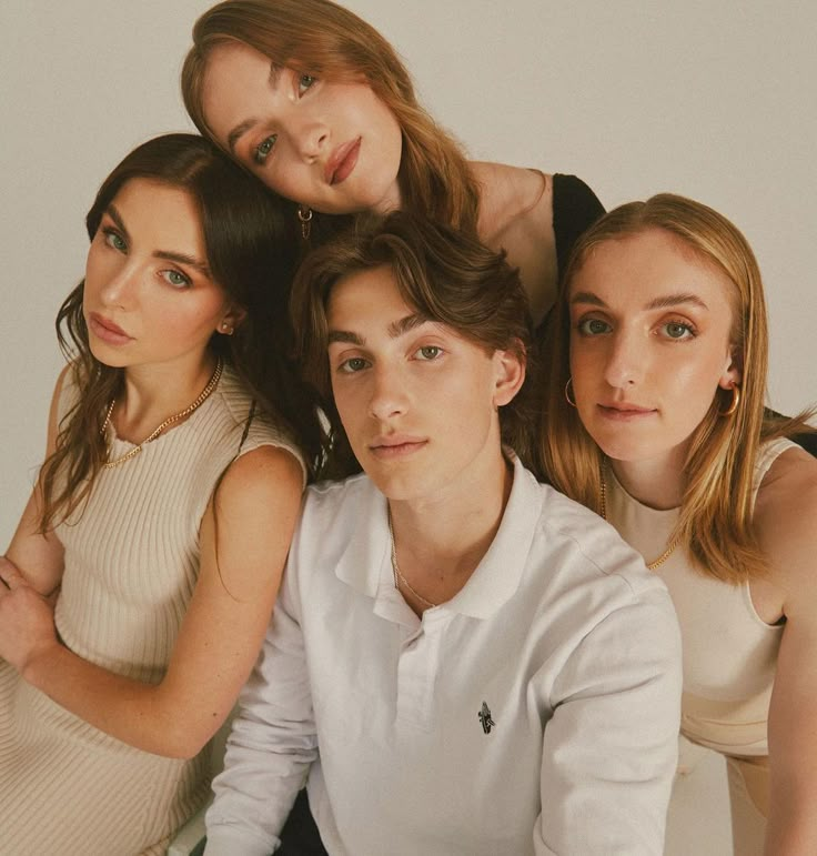 three women and one man are posing for the camera