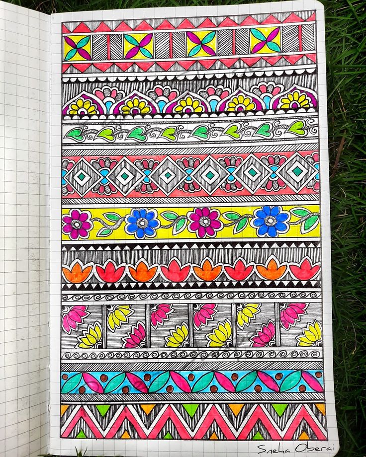 an open notebook with colorful designs on the pages and green grass in the foreground