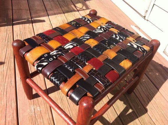 a small wooden chair with leather straps on the back and sides, sitting on a deck