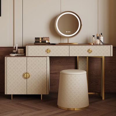 a dressing table with a mirror and stool next to it on a wooden floor in front of a window