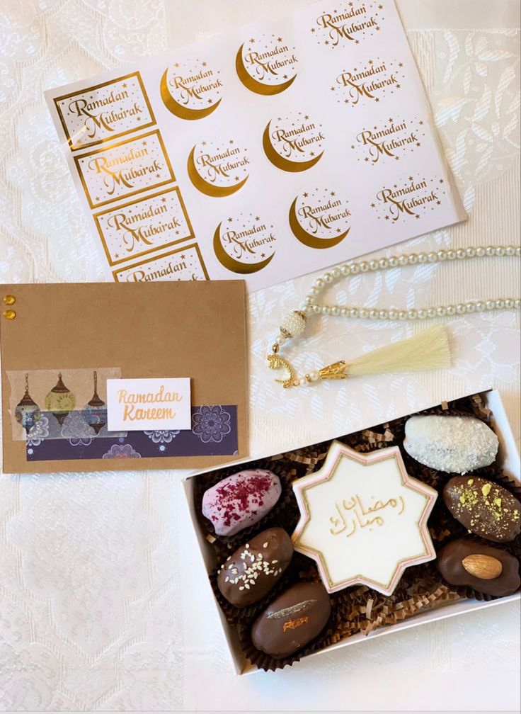 an assortment of chocolates in a box on a white tablecloth with gold foil