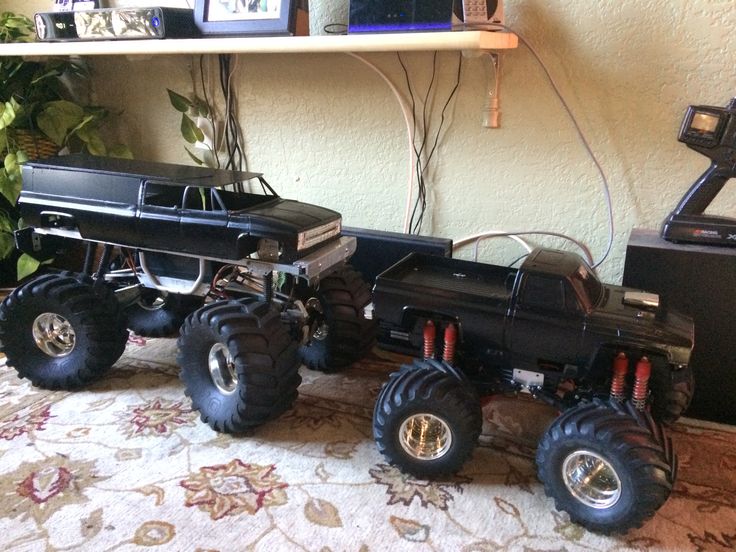 a toy truck with four large tires on top of a rug next to a shelf