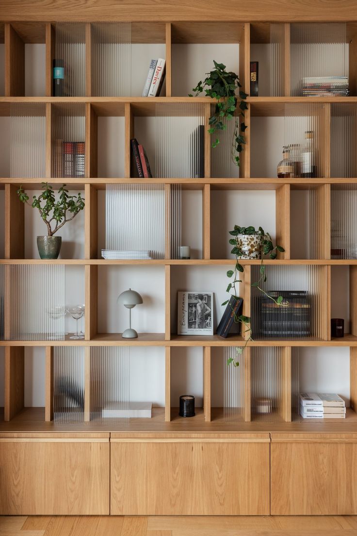 a wooden shelf filled with lots of books and plant life on top of it's shelves