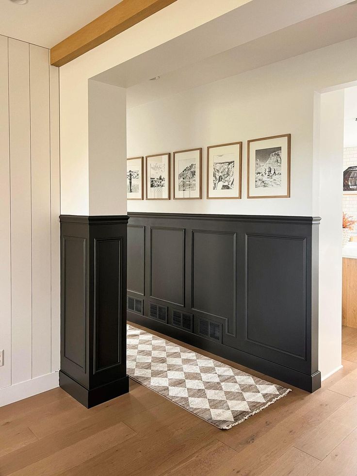 an empty living room with black cabinets and checkered rug on the hardwood flooring