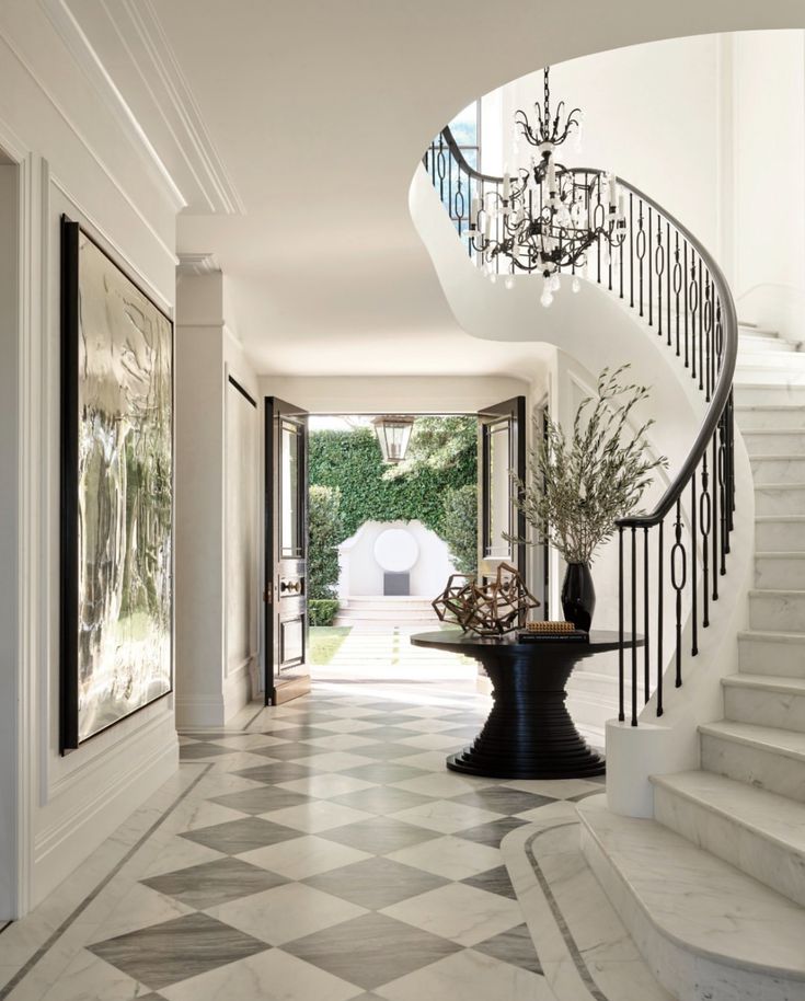 an elegant foyer with marble flooring and chandelier