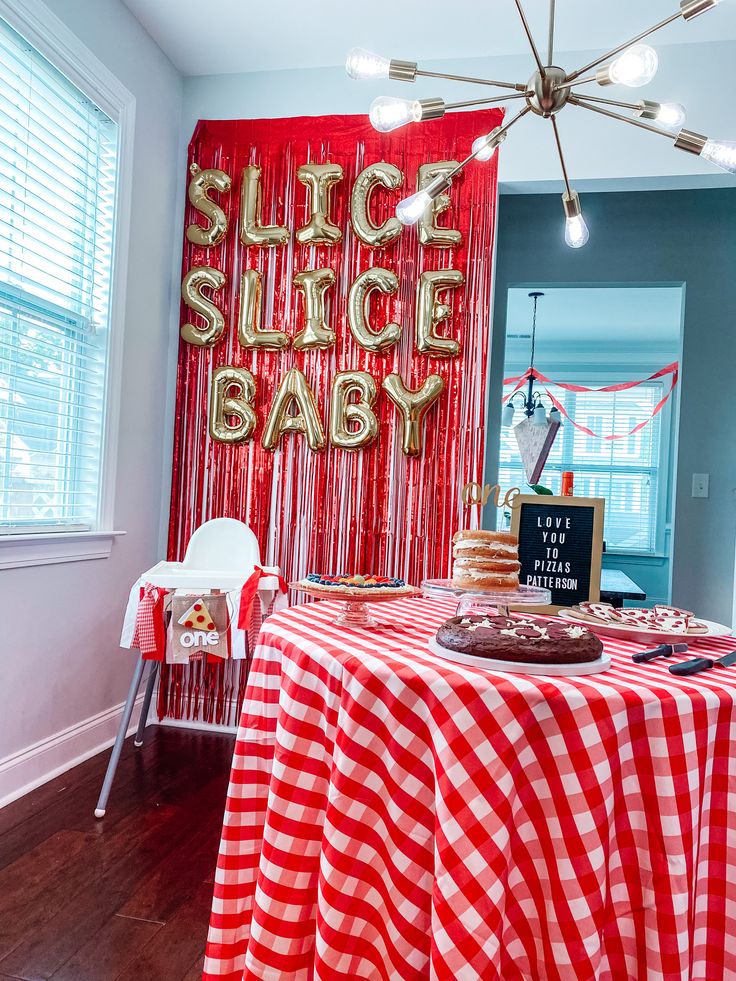 a red and white checkered table cloth with gold foil lettering on the wall behind it