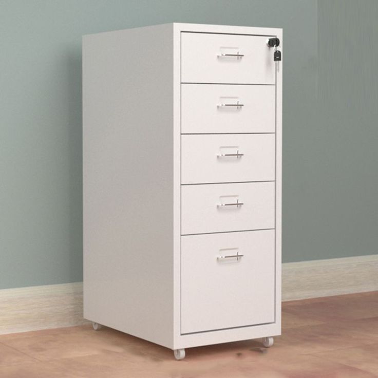 a white filing cabinet sitting on top of a hard wood floor next to a wall