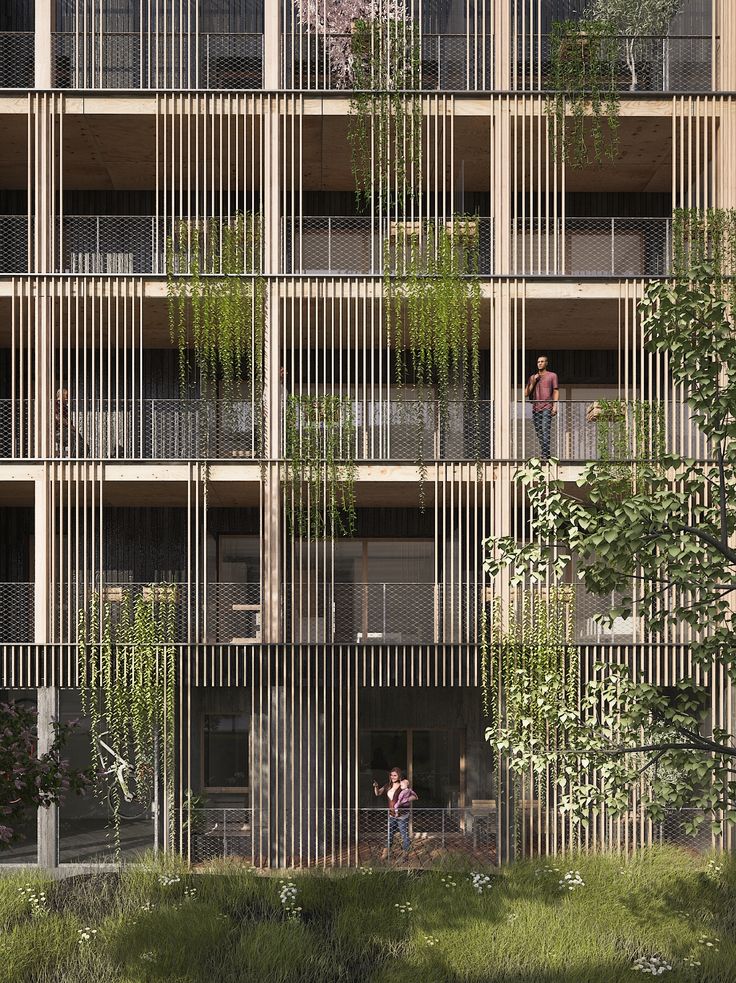 two people standing on the balconies of an apartment building with plants growing out of them