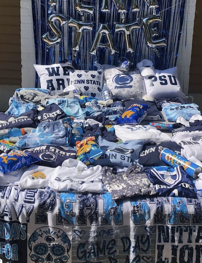 a bed covered in blue and white sheets with some foil letters on the headboard