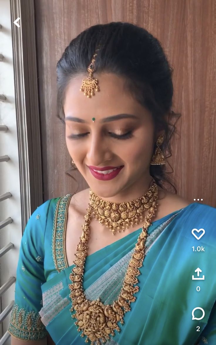 a woman in a blue sari with gold jewelry